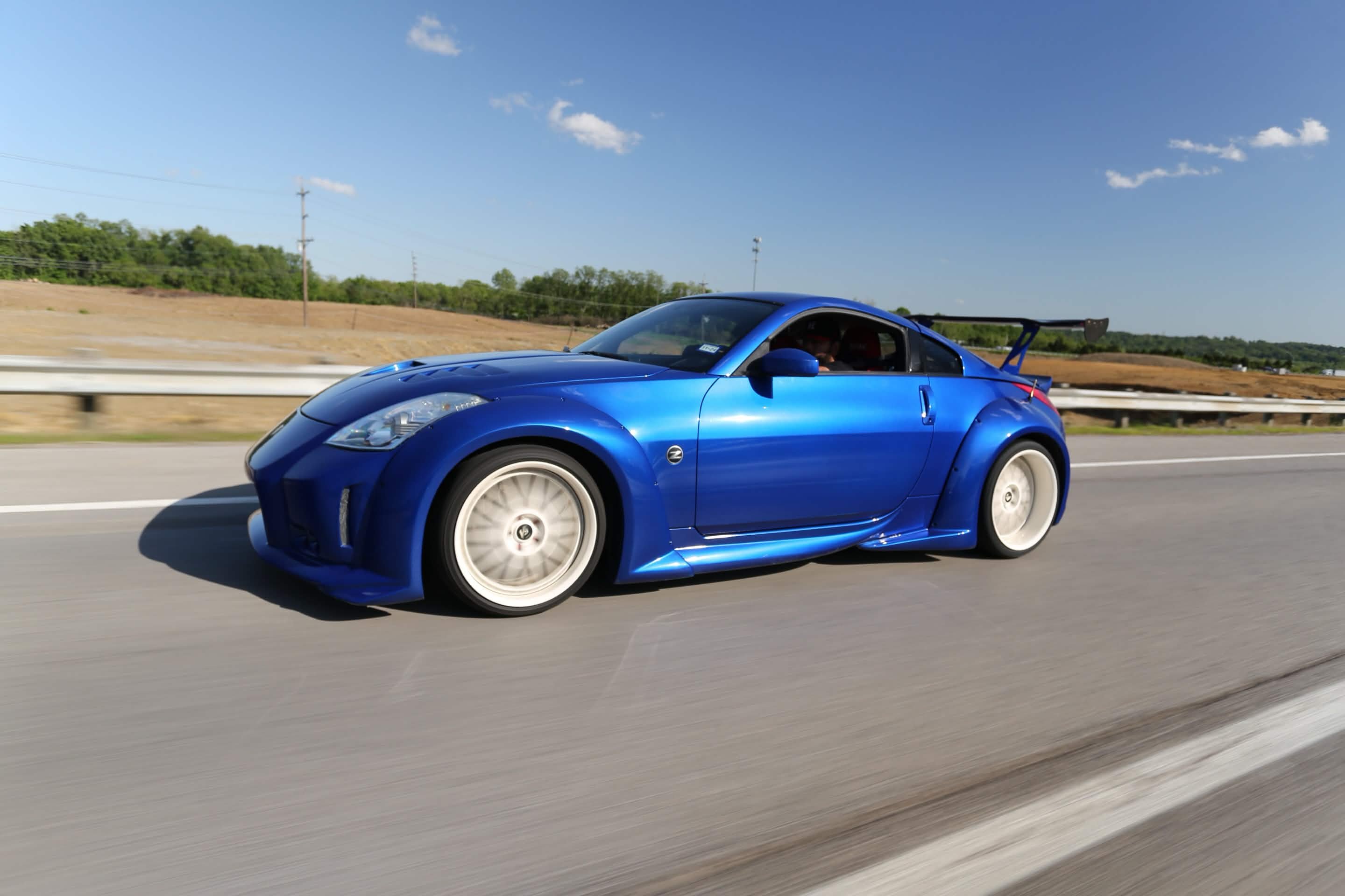 Blue Nissan 350Z wide-body rolling Indiana highway — Welchiani Media
